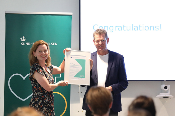 Martine Ingvorsen, Policy officer European Commission, DG SANTE, Disease Prevention and Health Promotion, presents a certificate of exemplary practice to Søren Brostrøm Director General, Danish Health Authority